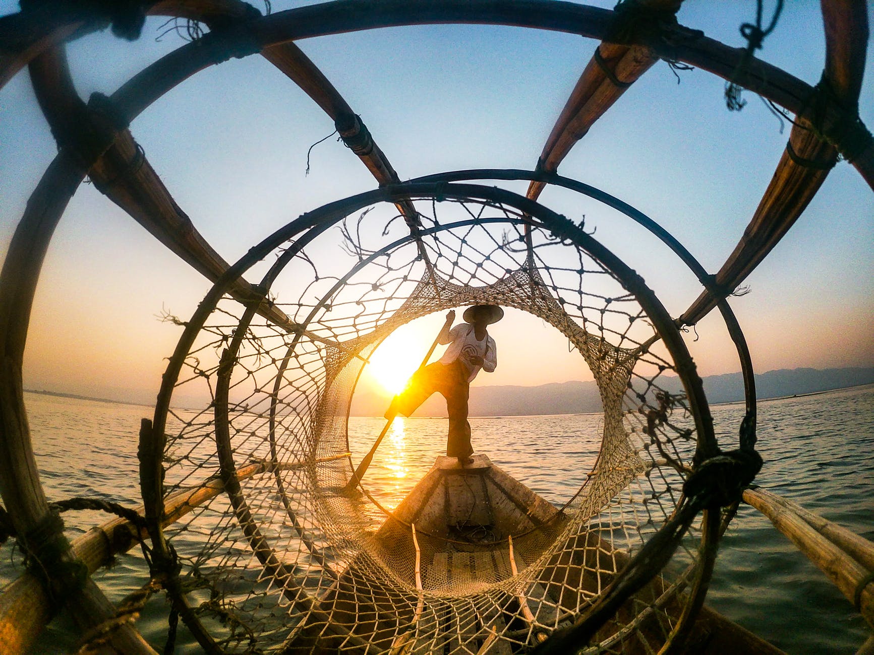 man standing on boat during sunrise
