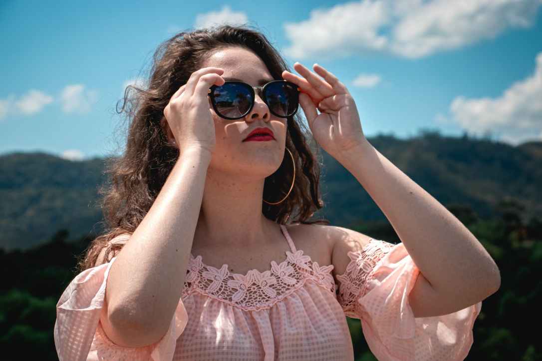 photo of woman holding her shades