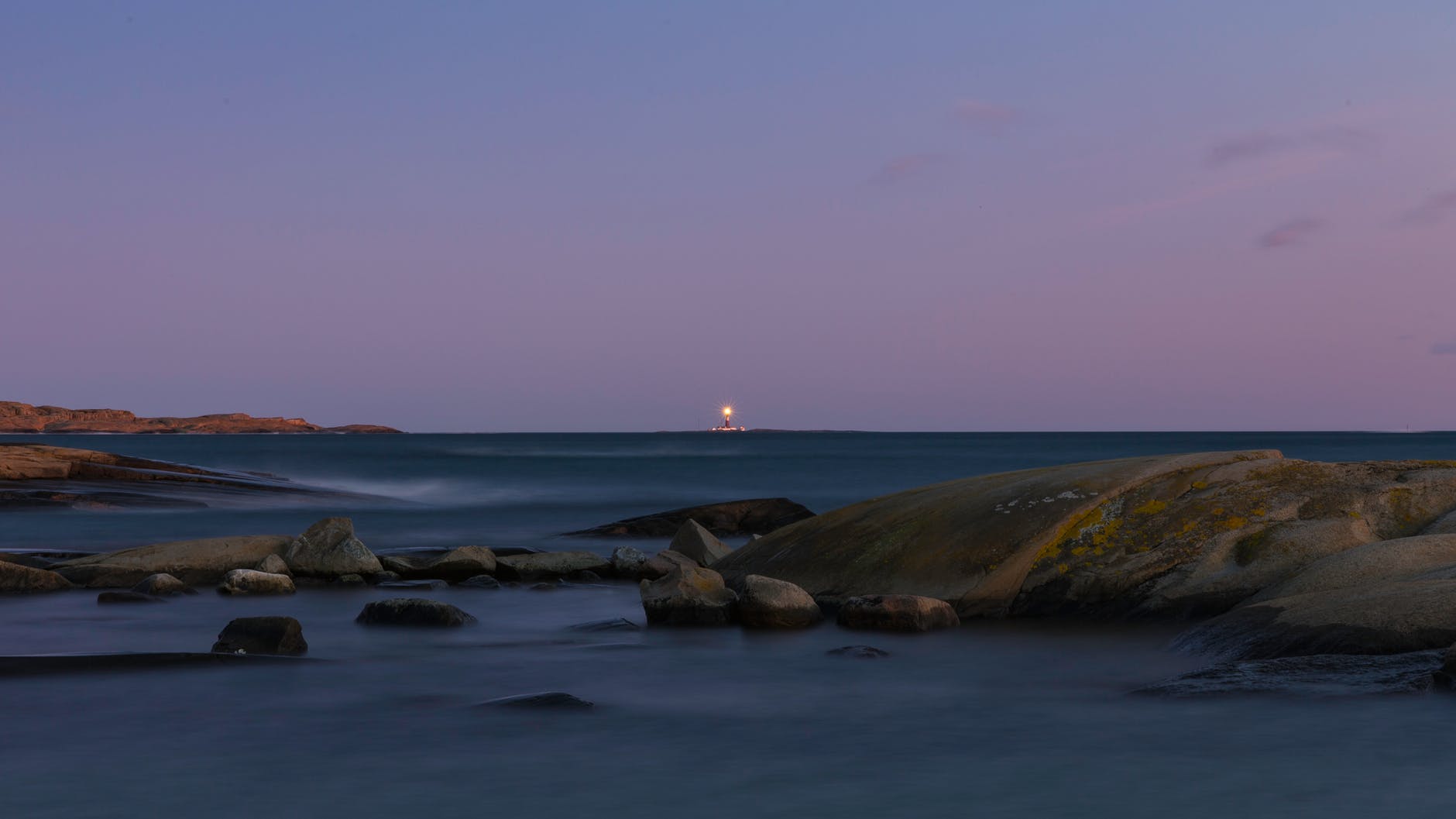 photo of body of water with boulders